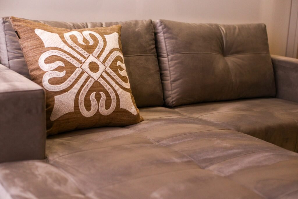 A close-up of an elegant gray sofa with an artistic decorative cushion in a modern living room.